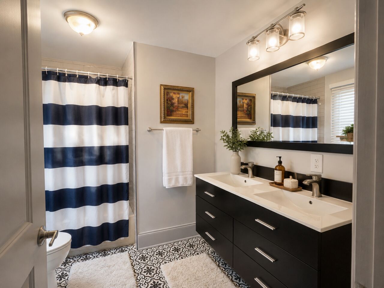 A bathroom with a double vanity and a large mirror