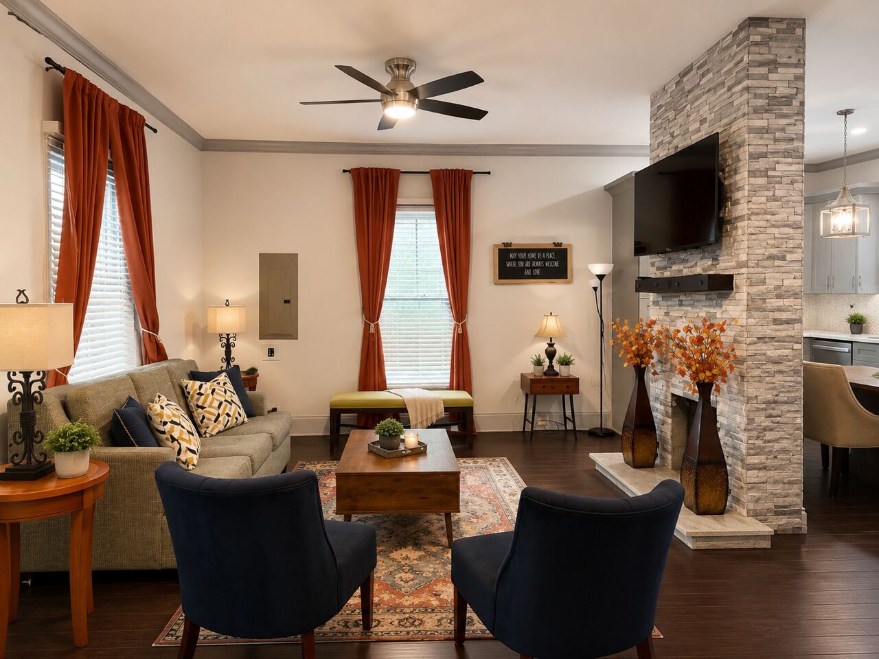 The shared living room with a stone fireplace and armchairs