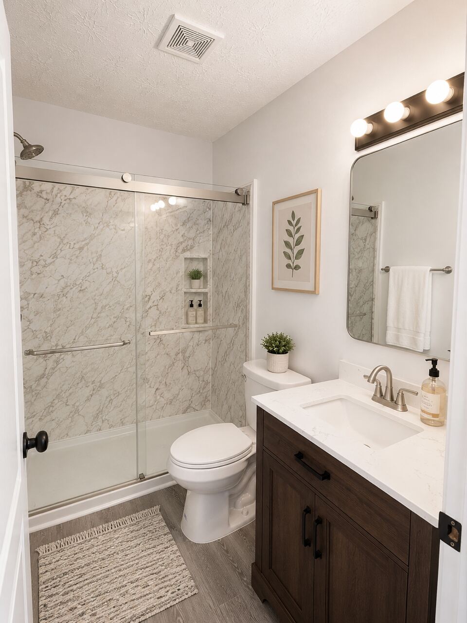 A private en suite bathroom with marble tile and a glass shower