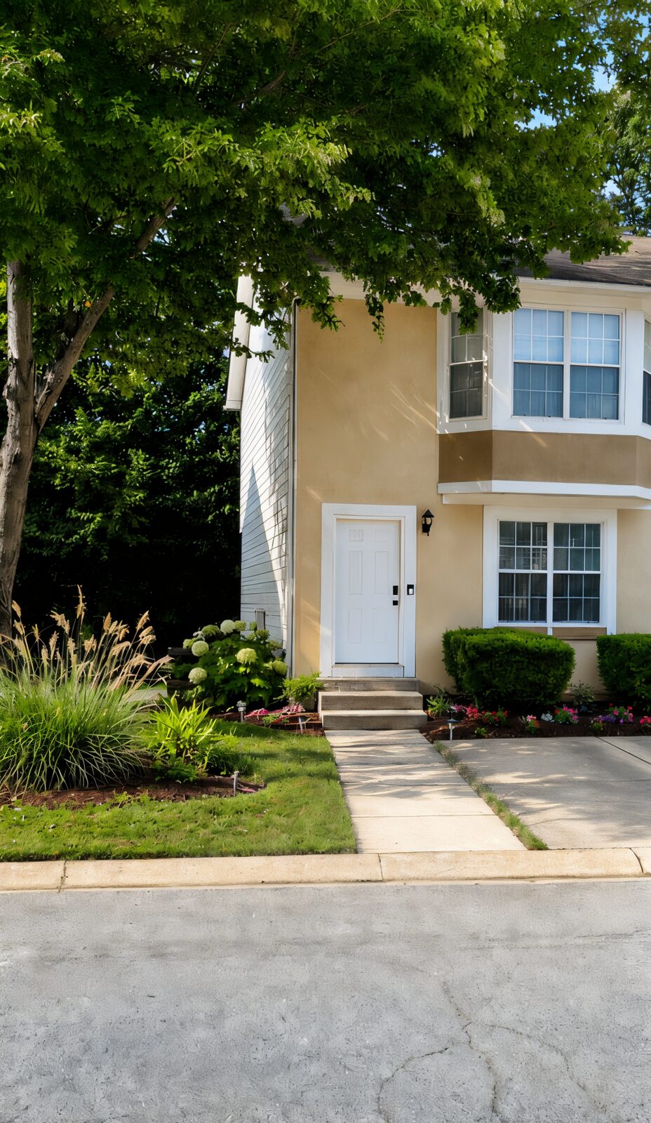 The front of Chupp’s Place, a cream townhome with landscaped beds in Lithonia