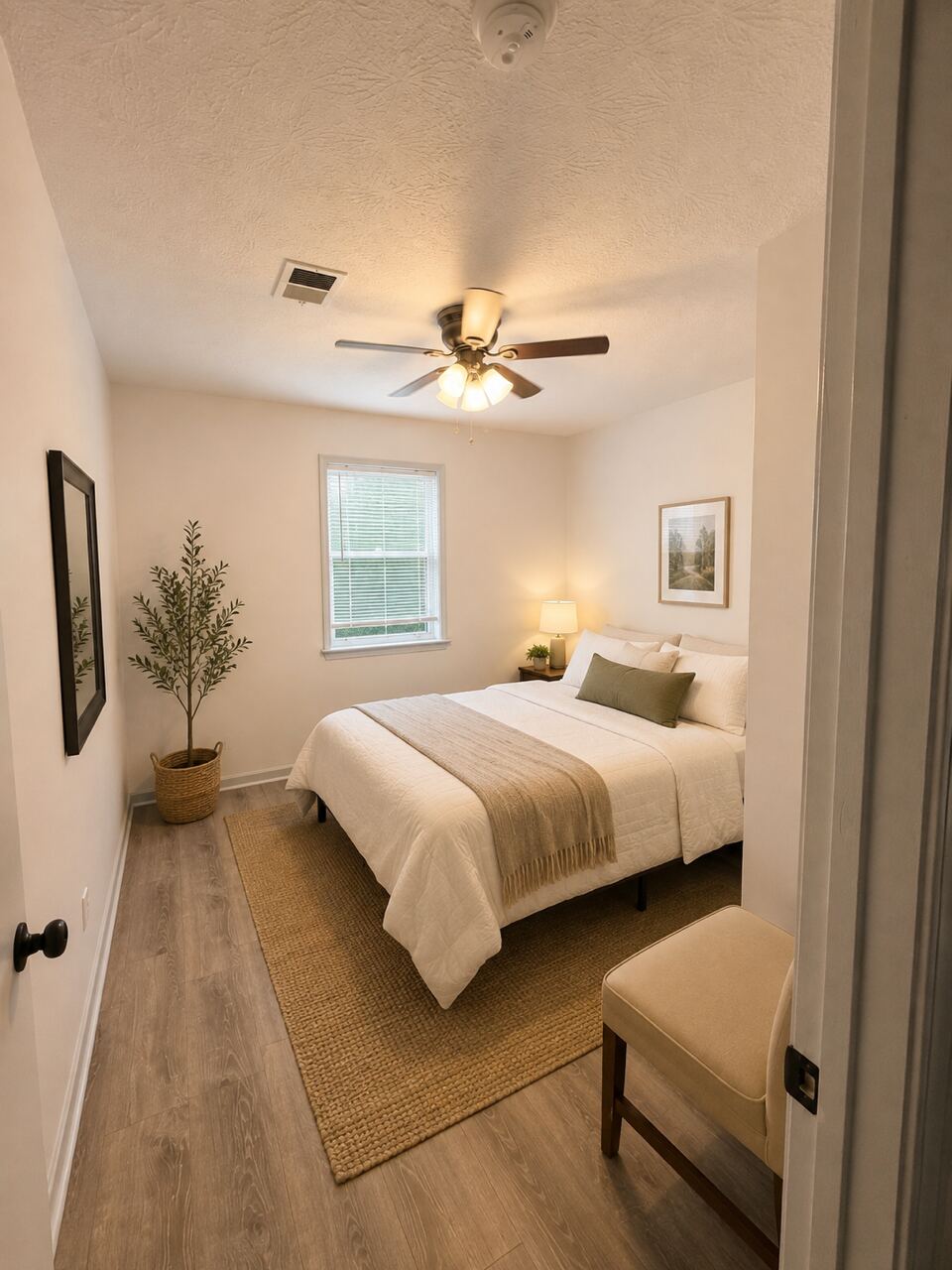A furnished private bedroom with a ceiling fan